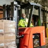 Smiling Lineage employee on a forklift